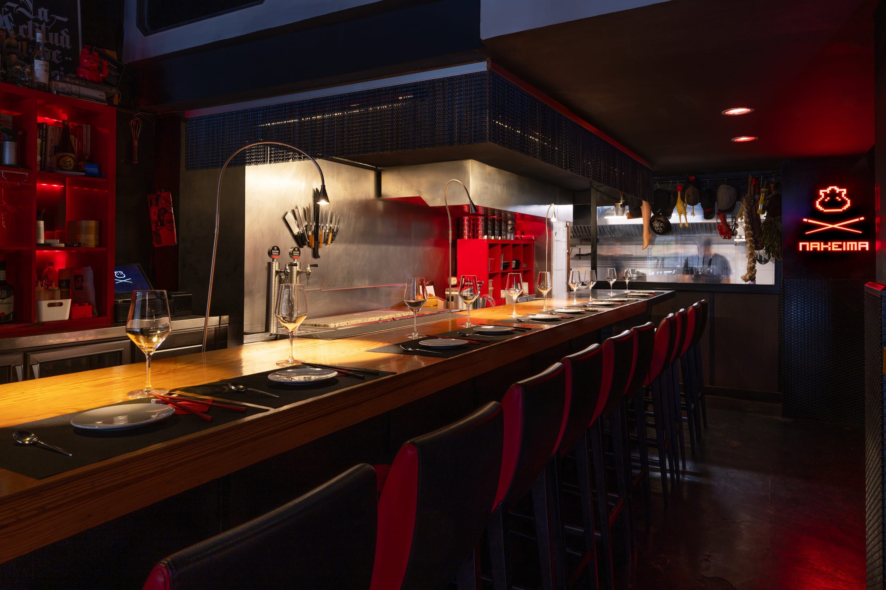 La barra de Nakeima, con sus sillas rojas y el neón del logo